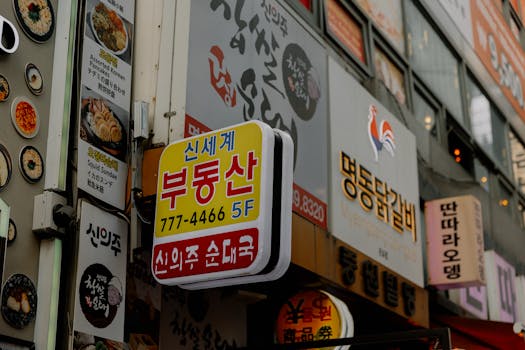 Vibrant street signs and restaurant facades in a bustling Korean city street scene.