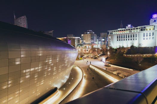 A stunning night shot of Dongdaemun Design Plaza in Seoul with illuminated cityscape.
