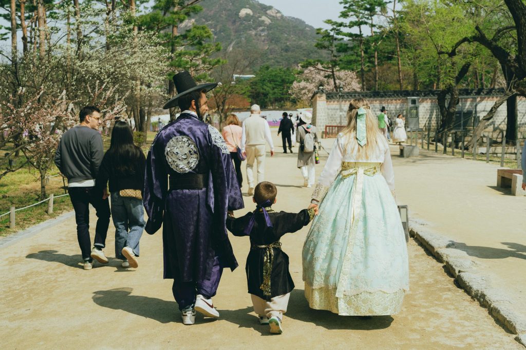 A family wearing traditional Hanbok enjoys a spring day at a Seoul park.